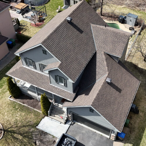 Vue aérienne d'une maison résidentielle avec une nouvelle toiture réalisée par Zoom Toiture, utilisant des matériaux GAF. Grande maison résidentiel, beige, blanc, moderne, Québec, Canada