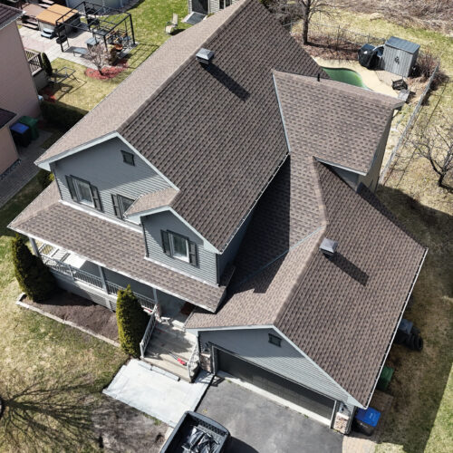 Vue aérienne d'une maison résidentielle avec une nouvelle toiture réalisée par Zoom Toiture, utilisant des matériaux GAF. Grande maison résidentiel, beige, blanc, moderne, Québec, Canada